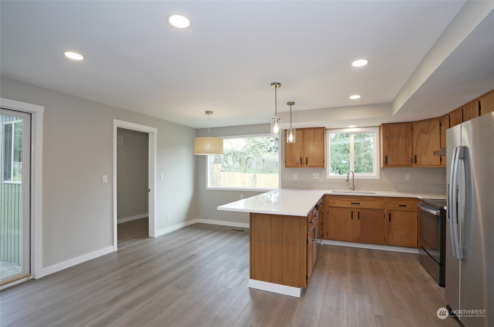 11012 Military Road Southwest Lakewood, WA 98498 - Photo 12 of 34 a kitchen with stainless steel appliances granite countertop a refrigerator a sink dishwasher a stove and white countertops with wooden floor
