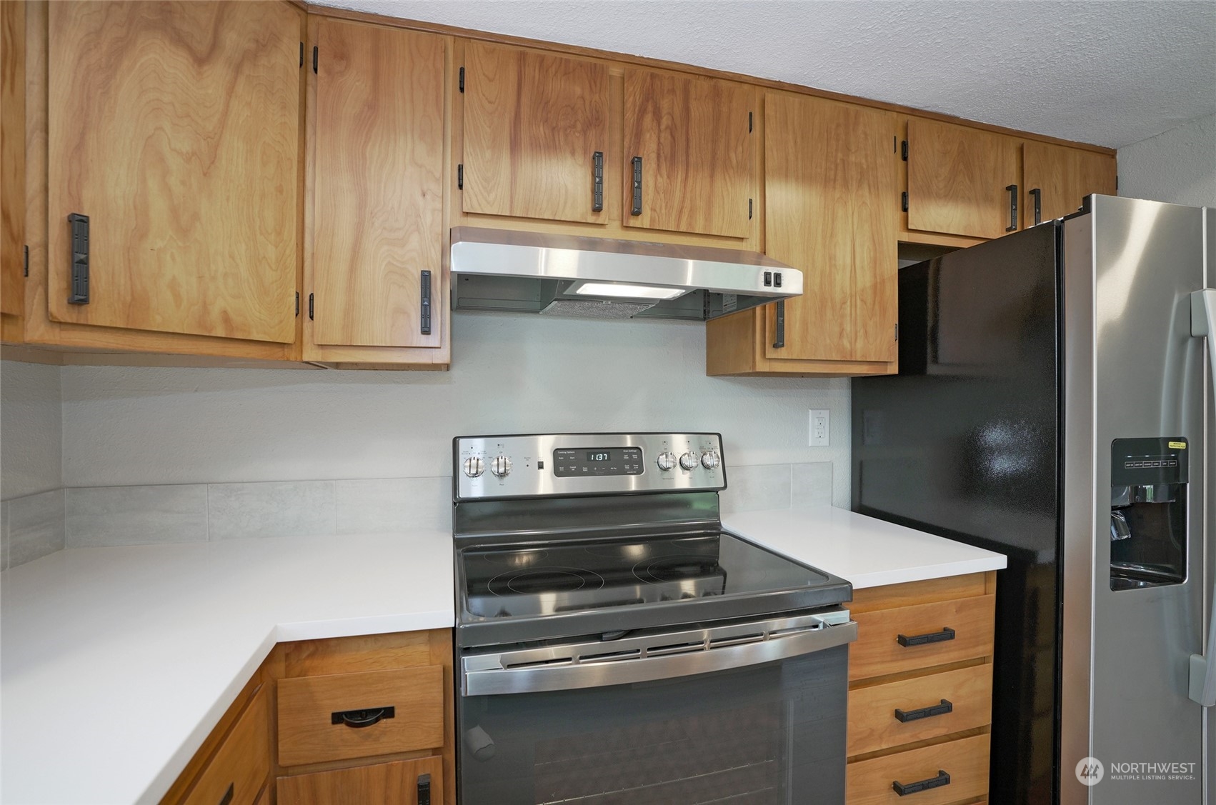 11012 Military Road Southwest Lakewood, WA 98498 - Photo 14 of 34 a kitchen with granite countertop a stove and a refrigerator with cabinets