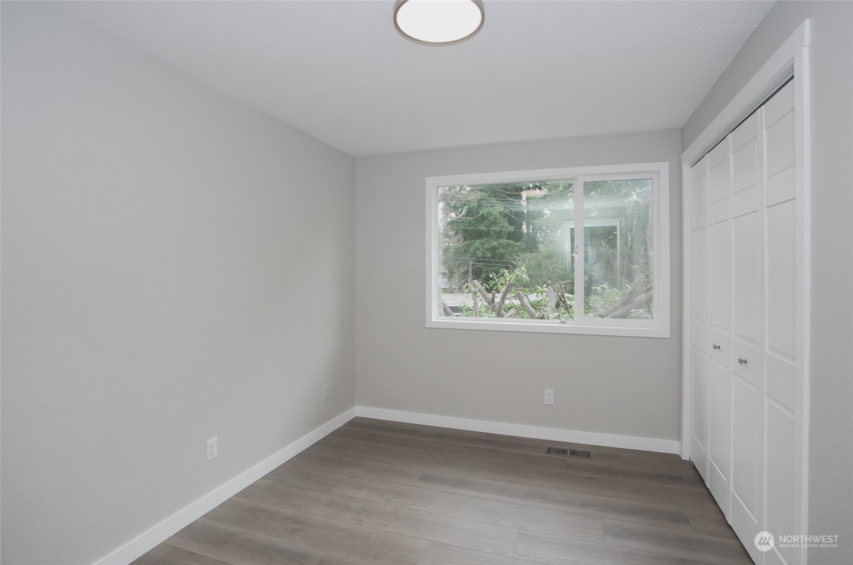11012 Military Road Southwest Lakewood, WA 98498 - Photo 25 of 34 an empty room with wooden floor and windows