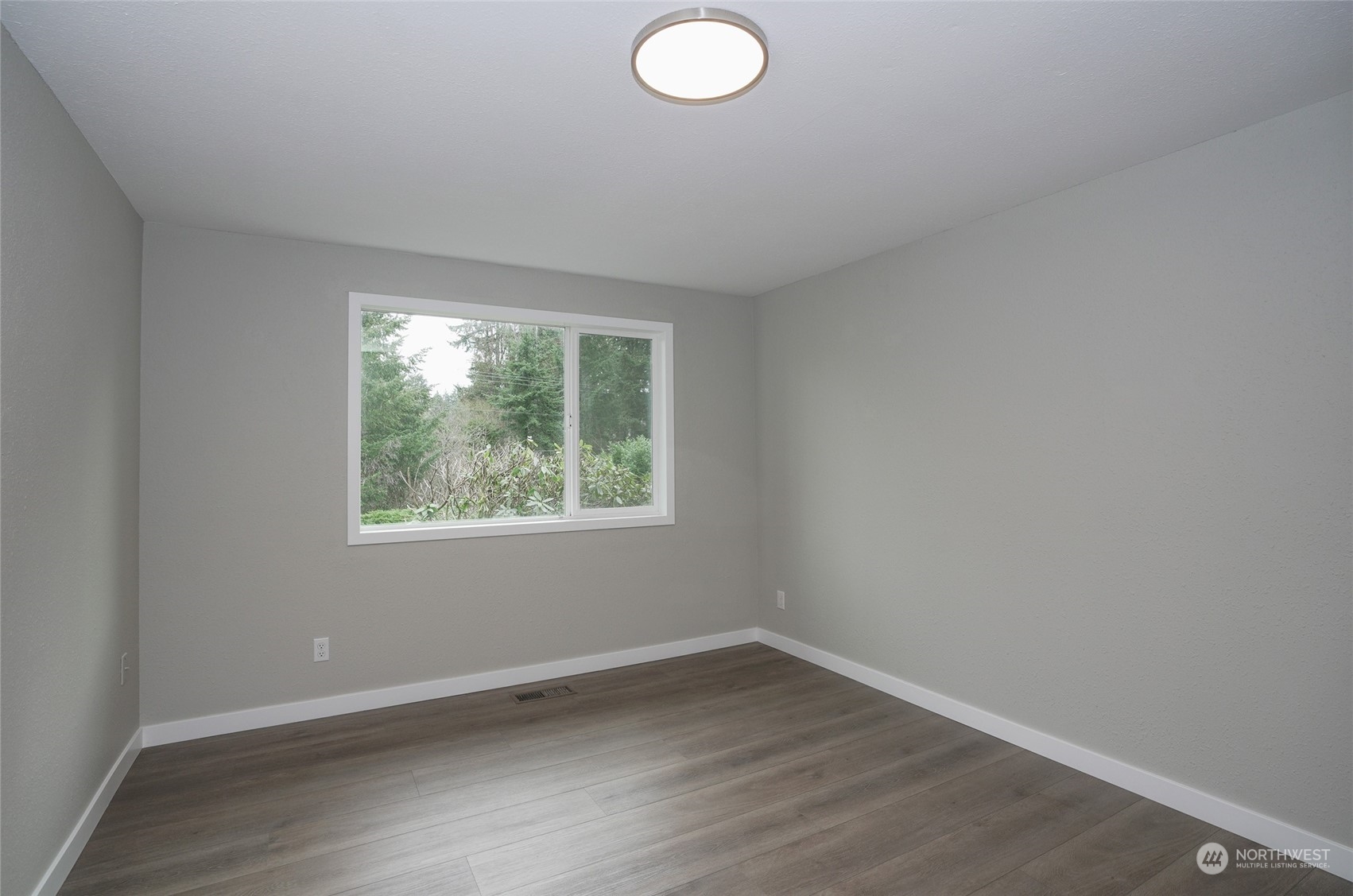 11012 Military Road Southwest Lakewood, WA 98498 - Photo 26 of 34 an empty room with wooden floor and windows