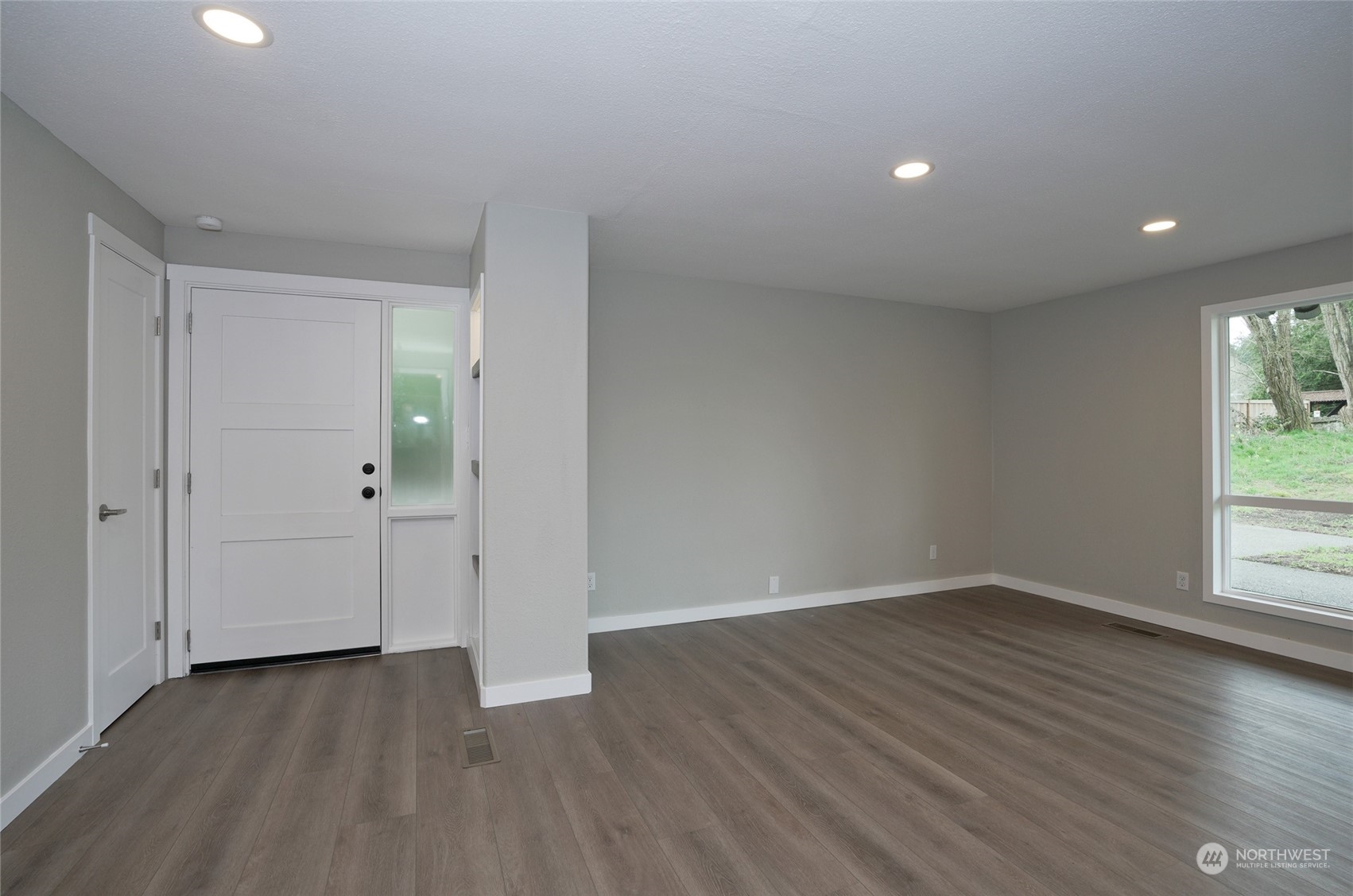 11012 Military Road Southwest Lakewood, WA 98498 - Photo 5 of 34 an empty room with wooden floor and windows
