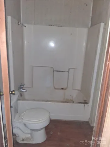 a bathroom with a toilet and a shower