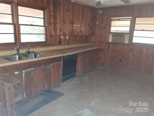 a kitchen with a sink window and cabinets