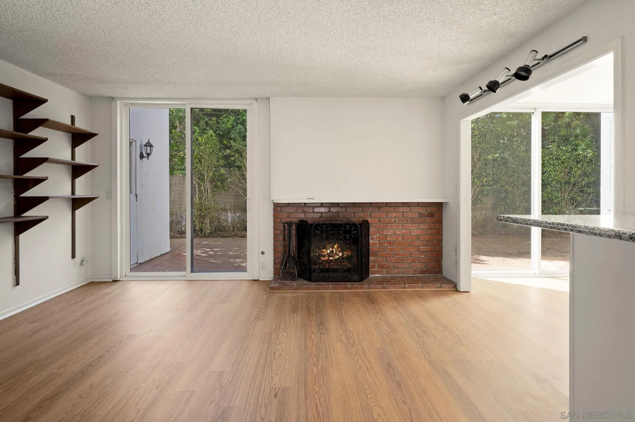 2847 Via Posada La Jolla, CA 92037 - Photo 14 of 21 a view of an empty room with wooden floor fireplace and a window