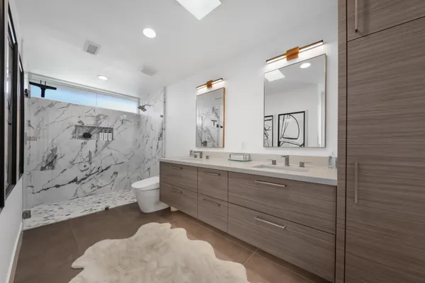 a bathroom with a double vanity sink toilet and shower