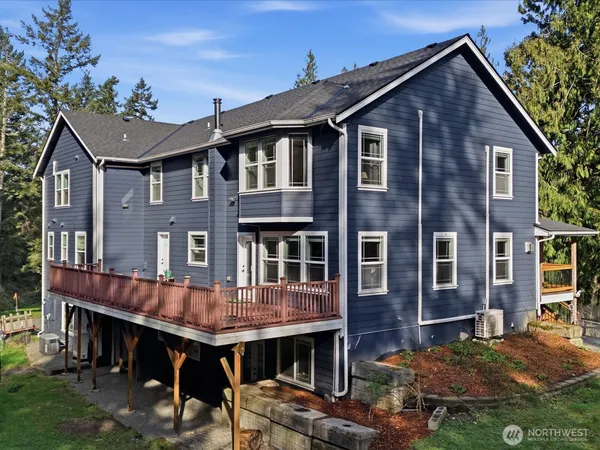 a view of a house with wooden deck and furniture