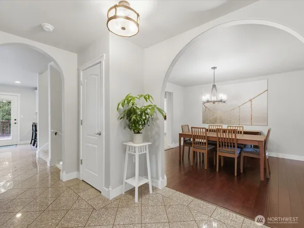a dining room filled chandelier and kitchen view
