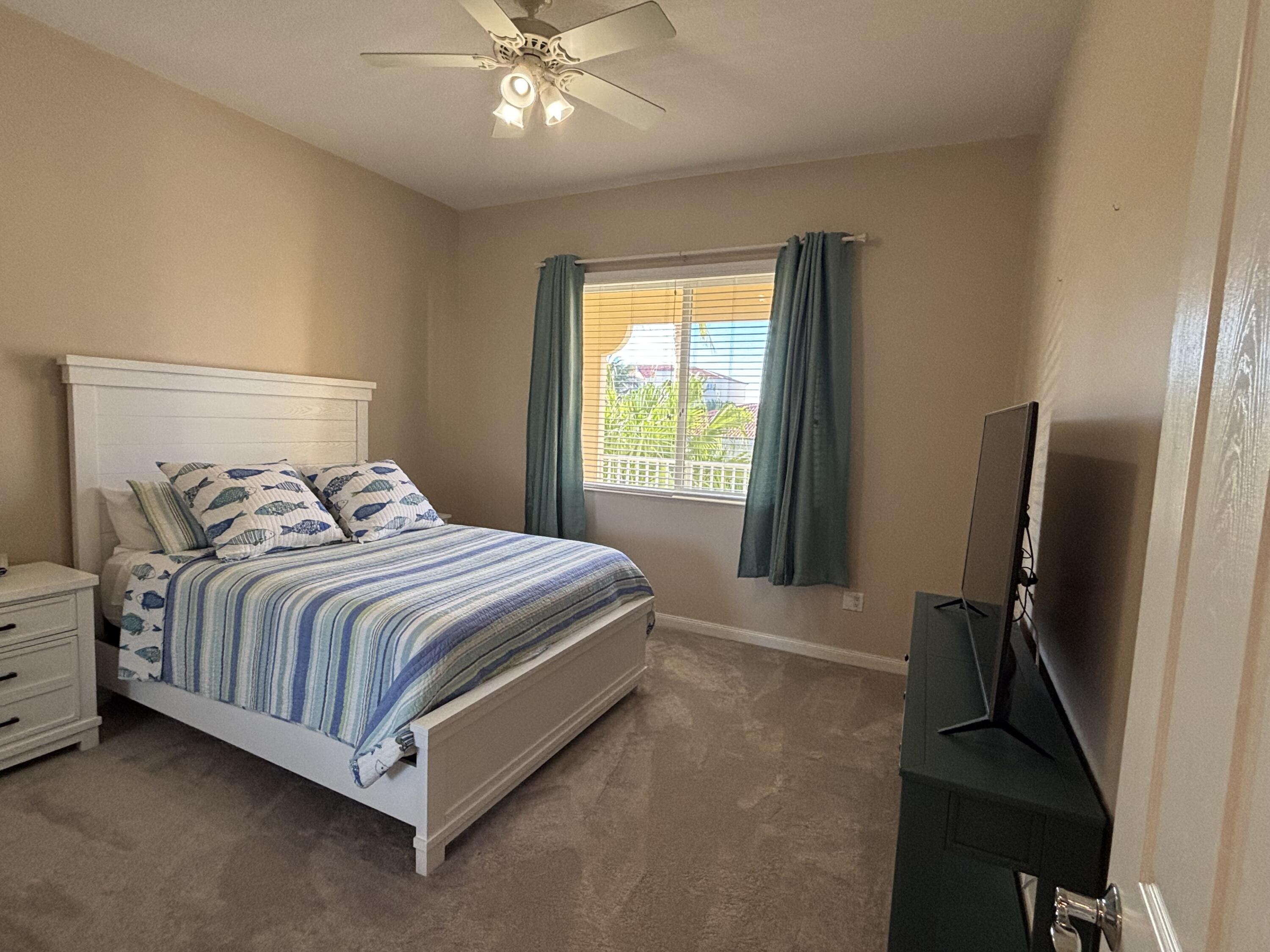 14 Harbour Isle Drive West, Unit 202 Fort Pierce, FL 34949 - Photo 14 of 18 a bedroom with a bed and a chandelier