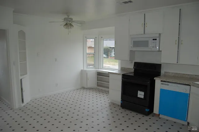 a kitchen with granite countertop a stove a sink and a refrigerator