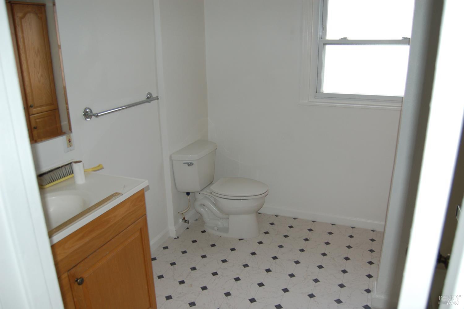 148 North 3rd Street Rio Vista, CA 94571 - Photo 7 of 11 a bathroom with a sink a toilet a window and vanity
