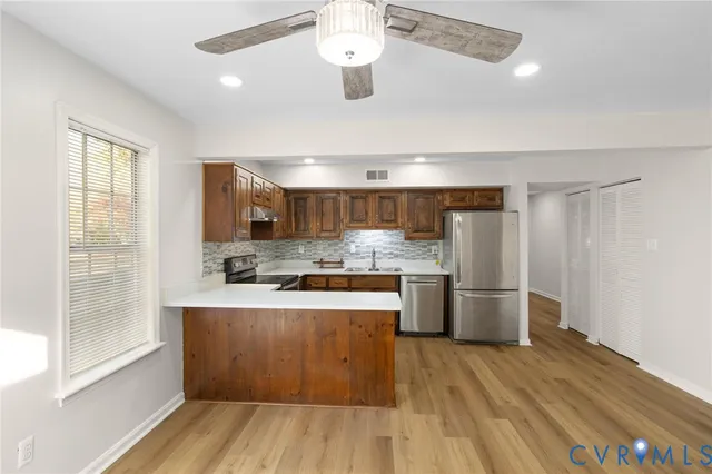 a large kitchen with a lot of counter space and wooden floor