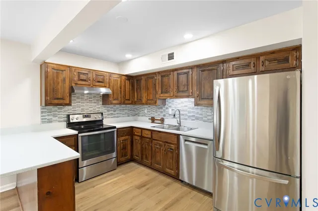 a kitchen with stainless steel appliances granite countertop a refrigerator stove microwave and sink