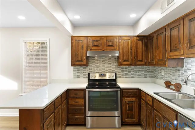 a kitchen with granite countertop a sink stove and cabinets