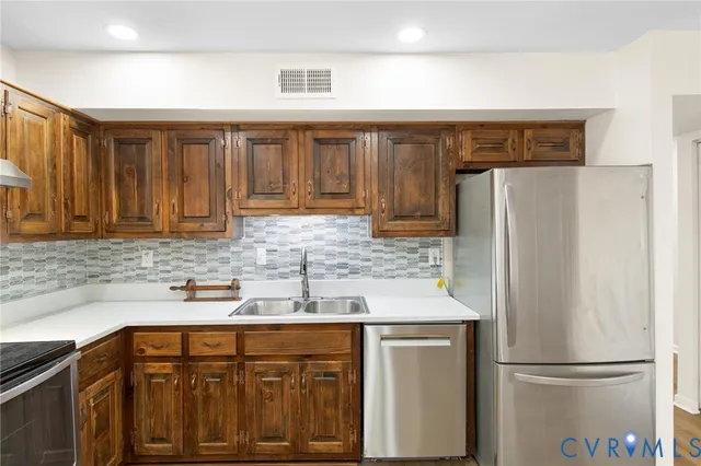 a kitchen with stainless steel appliances granite countertop a refrigerator and a sink