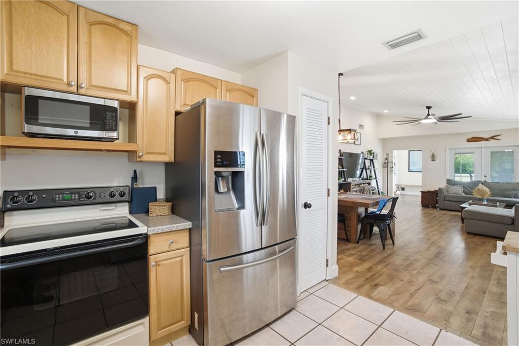 1286 Venetian Way Naples, FL 34110 - Photo 9 of 46 a kitchen with stainless steel appliances granite countertop a refrigerator stove and microwave