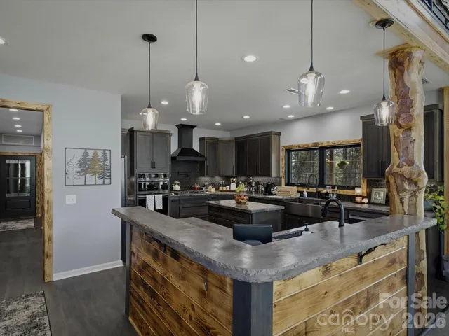 a kitchen with kitchen island a counter space a sink appliances and a counter top space