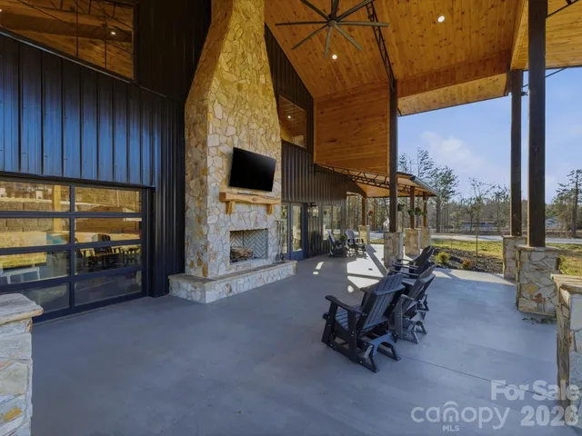 a living room with furniture a fireplace and floor to ceiling window