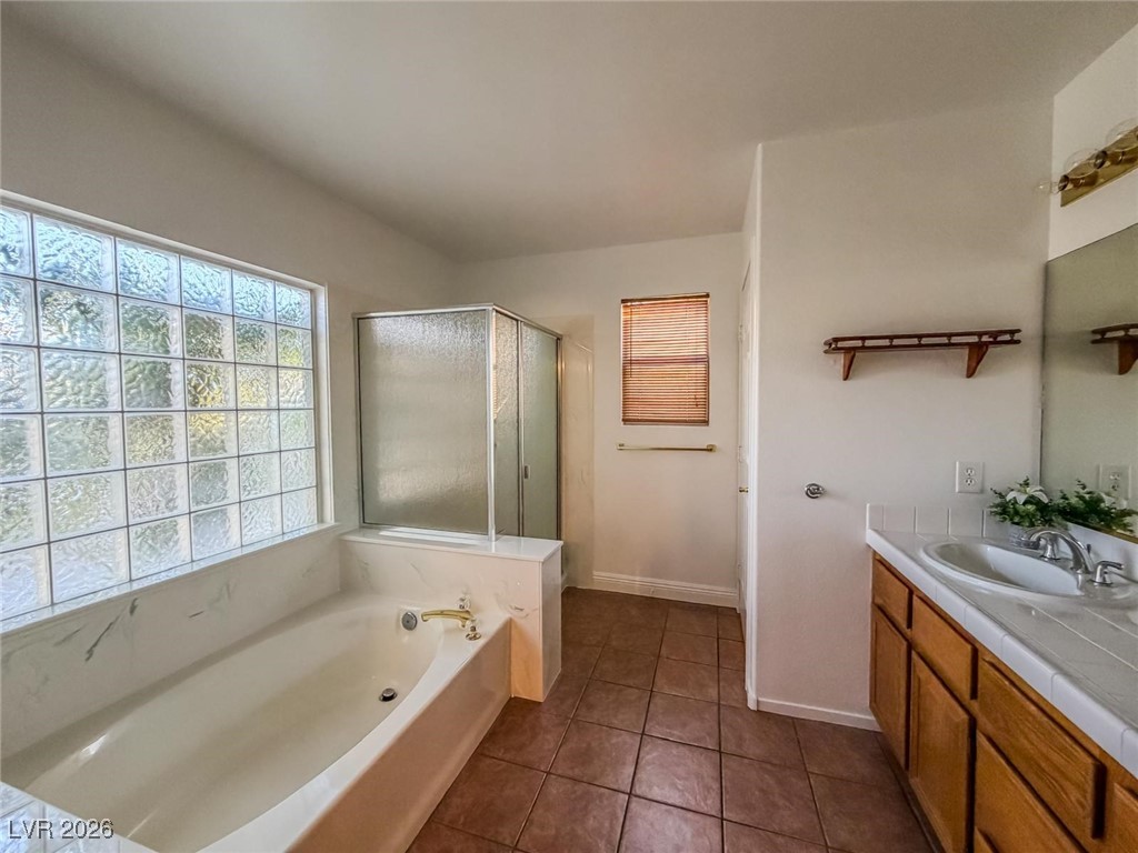 5308 Scoreboard Street Las Vegas, NV 89130 - Photo 18 of 32 Full bathroom featuring a shower stall, vanity, dark tile patterned floors, and a garden tub