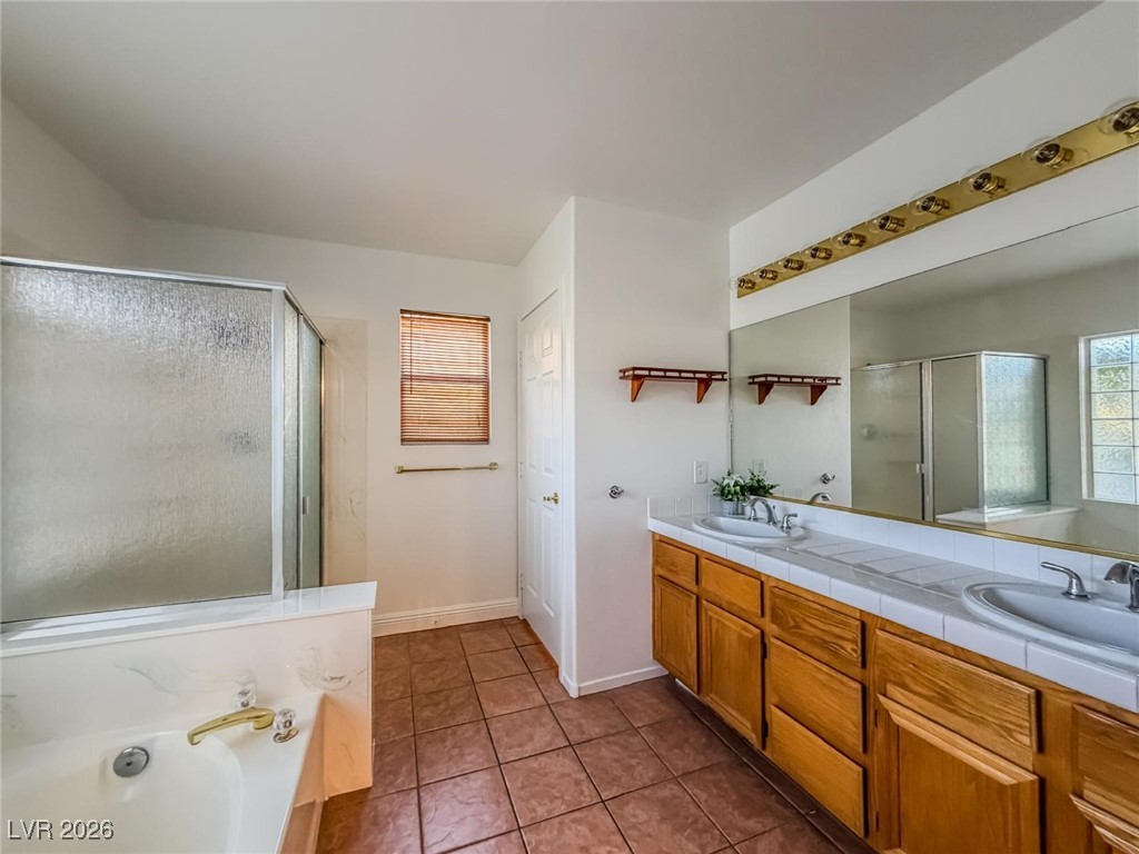 5308 Scoreboard Street Las Vegas, NV 89130 - Photo 19 of 32 Full bath with a garden tub, double vanity, a stall shower, light tile patterned floors, and healthy amount of natural light