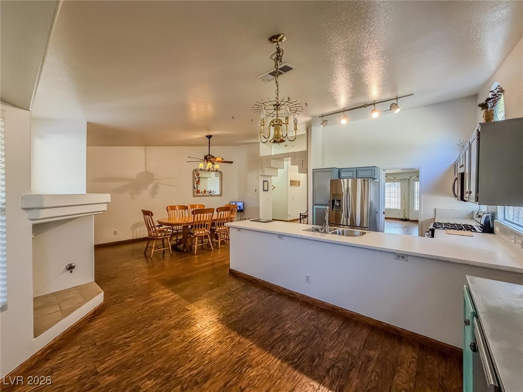 5308 Scoreboard Street Las Vegas, NV 89130 - Photo 24 of 32 Kitchen with light countertops, a peninsula, dark wood-style floors, stainless steel appliances, and a textured ceiling