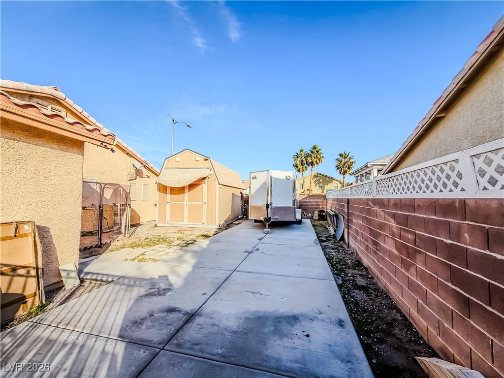 5308 Scoreboard Street Las Vegas, NV 89130 - Photo 30 of 32 Fenced backyard featuring a storage unit and a patio
