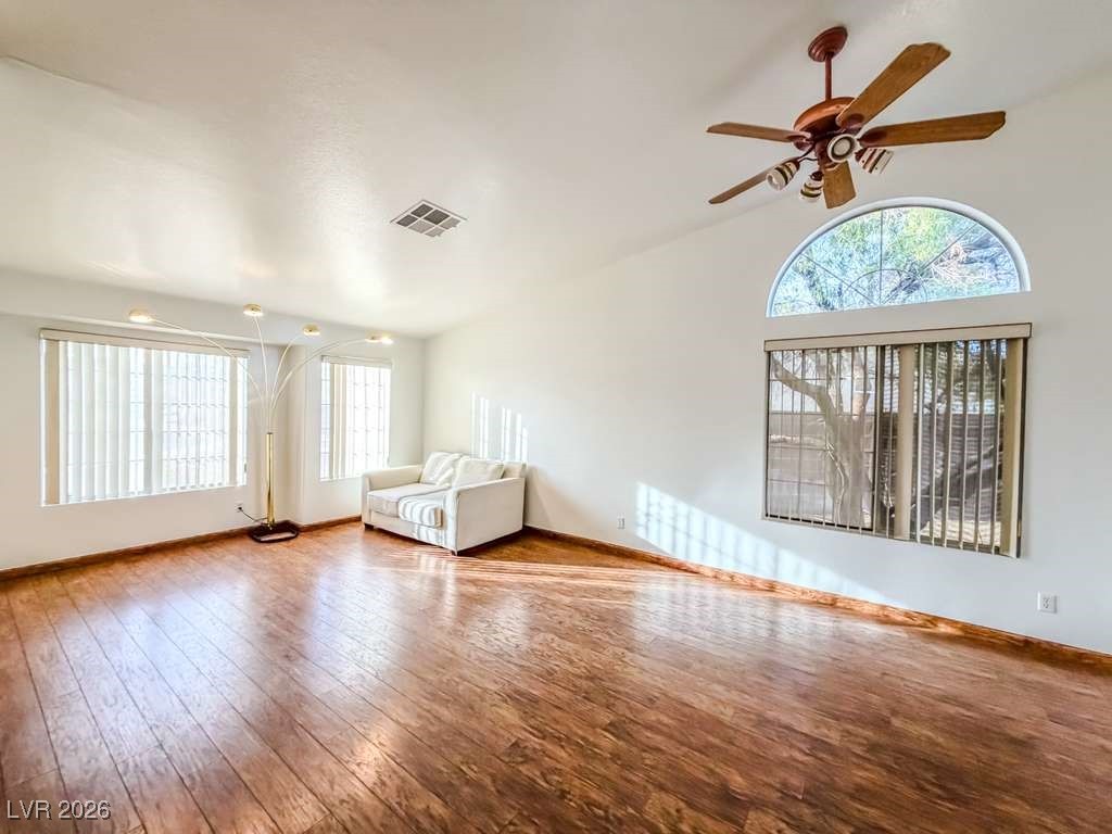 5308 Scoreboard Street Las Vegas, NV 89130 - Photo 4 of 32 Unfurnished living room with hardwood / wood-style floors, a ceiling fan, and a high ceiling