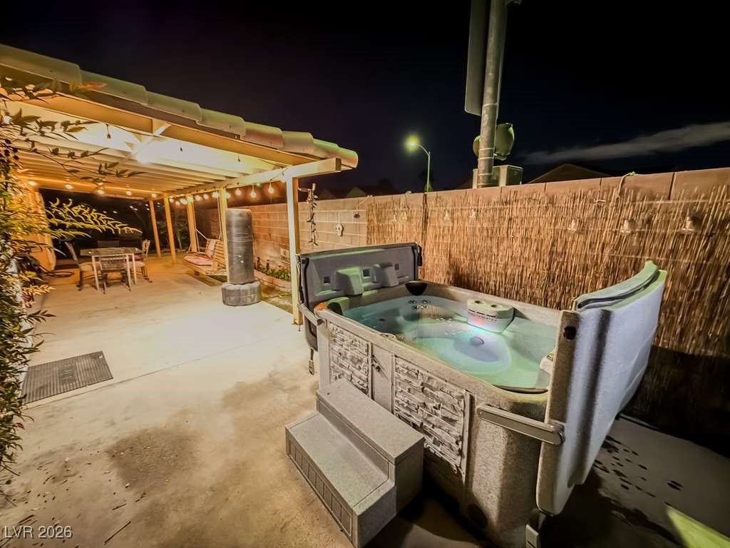 5308 Scoreboard Street Las Vegas, NV 89130 - Photo 7 of 32 Patio at twilight featuring a fenced backyard, a patio area, a hot tub, and outdoor dining space