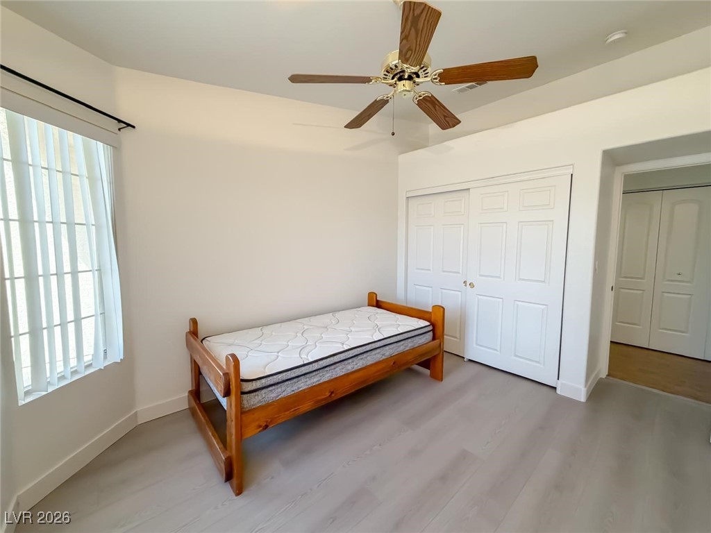 5308 Scoreboard Street Las Vegas, NV 89130 - Photo 10 of 32 Bedroom with light wood-style flooring, ceiling fan, and a closet