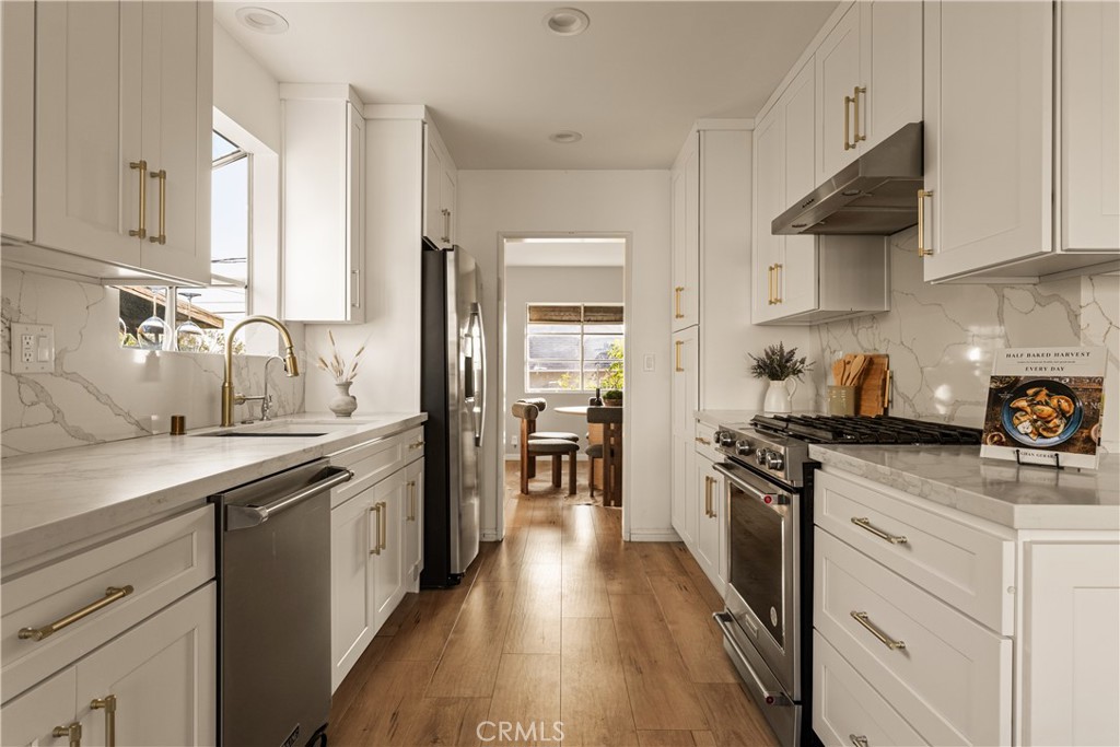 1819 Richard Street Burbank, CA 91504 - Photo 9 of 29 a kitchen with stainless steel appliances a sink dishwasher stove refrigerator and cabinets with wooden floor