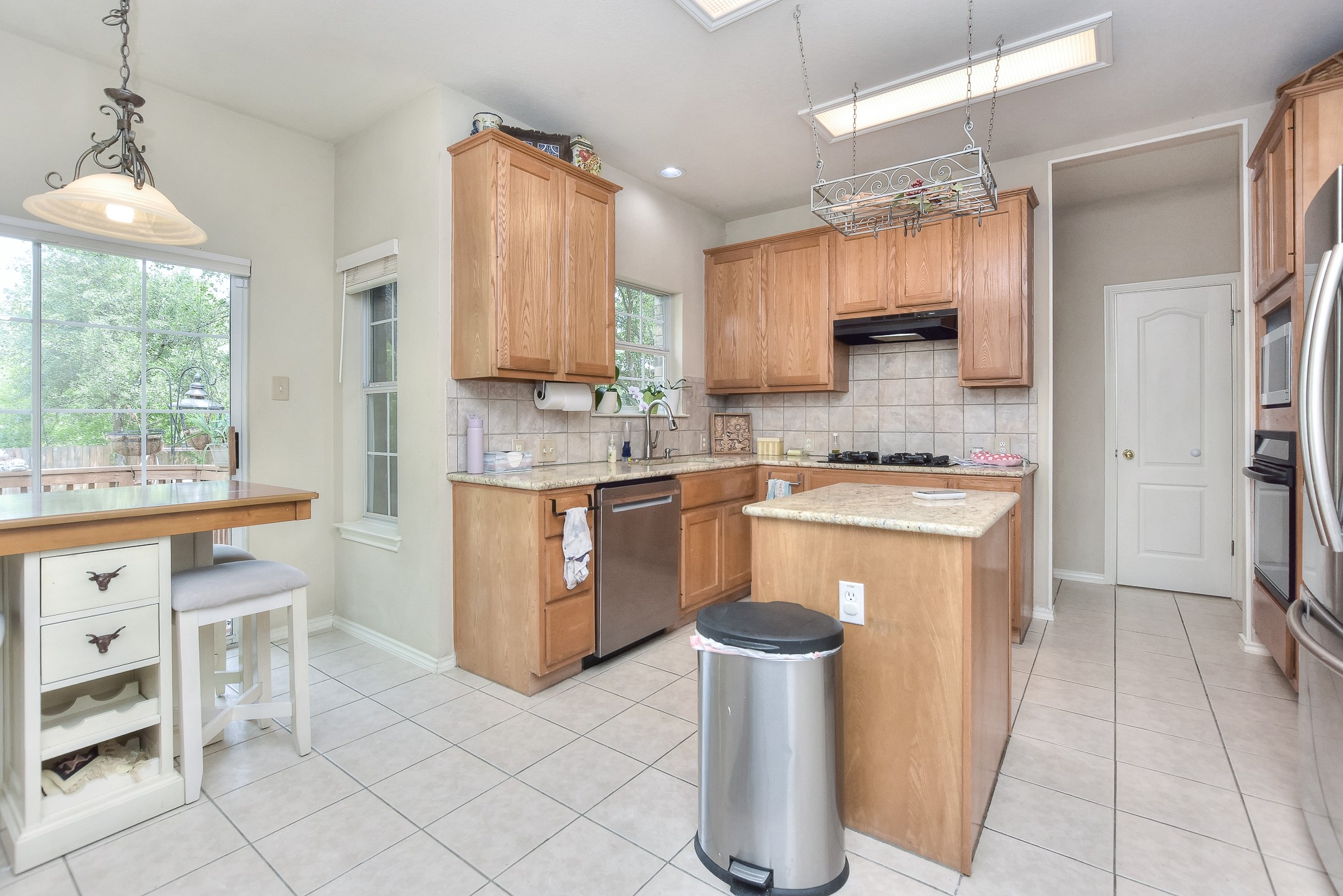 1609 Colton Way Cedar Park, TX 78613 - Photo 9 of 24 A well-appointed kitchen features natural wood cabinetry and a functional island, overlooking a serene outdoor deck.