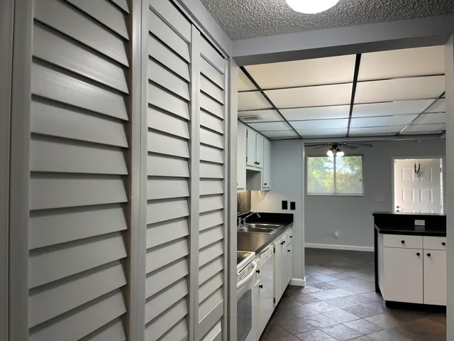 a kitchen with granite countertop white cabinets and stove