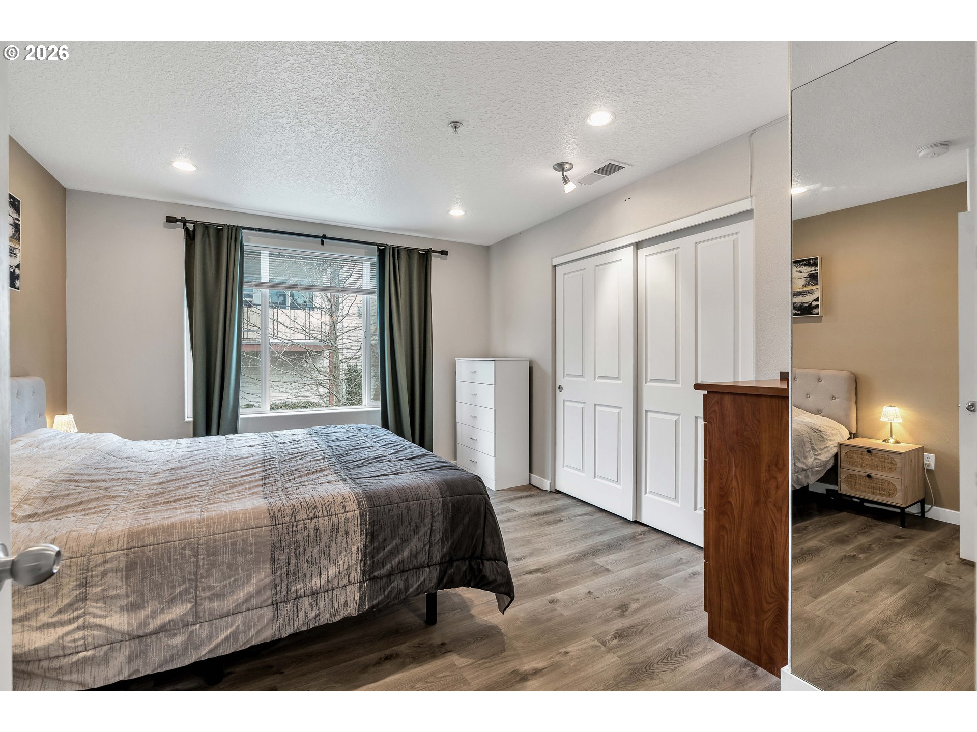 350 Northwest 116th Avenue, Unit 101 Portland, OR 97229 - Photo 23 of 38 a bedroom with a bed and wooden floor