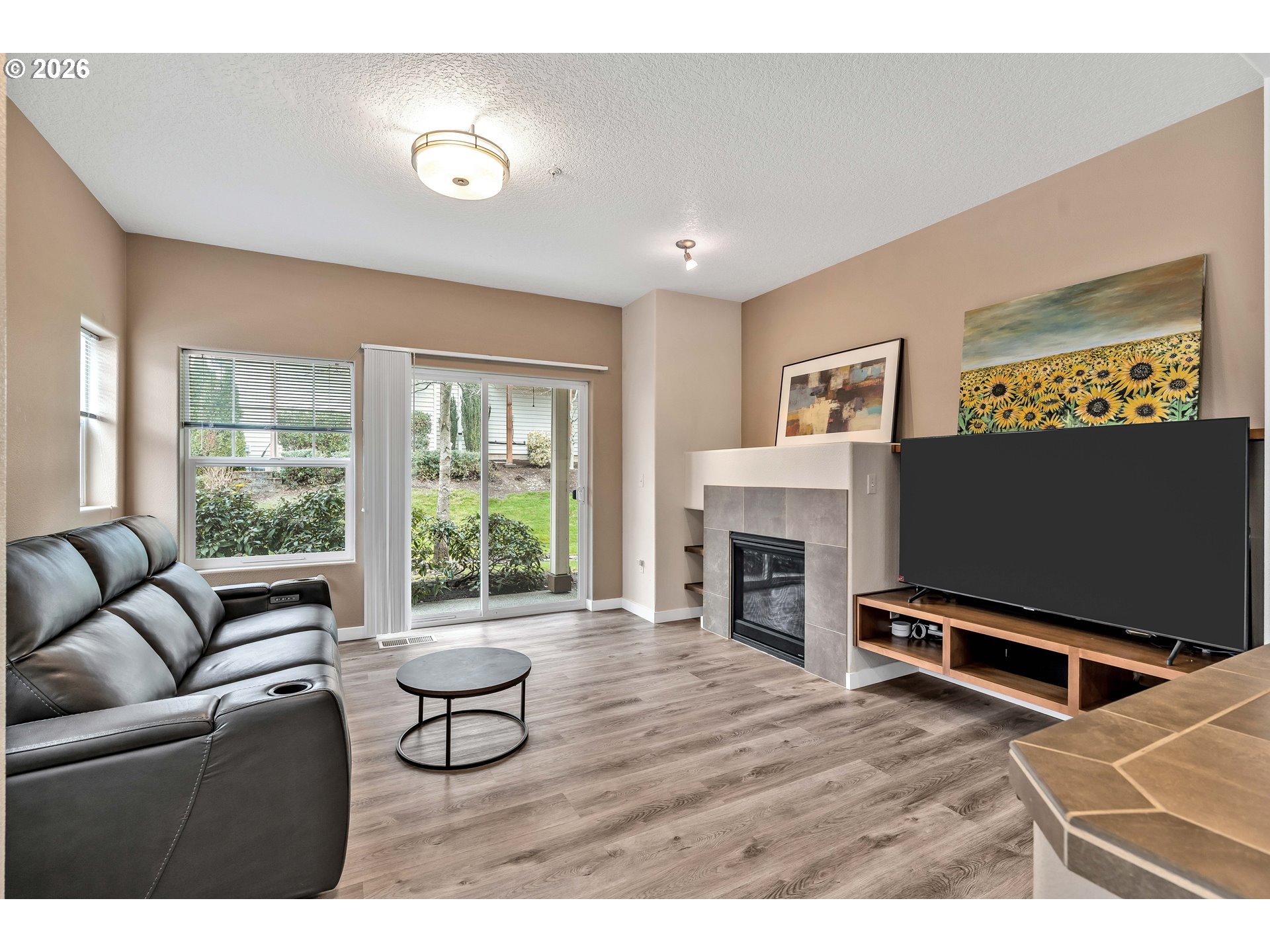 350 Northwest 116th Avenue, Unit 101 Portland, OR 97229 - Photo 6 of 38 a living room with furniture a fireplace and a flat screen tv