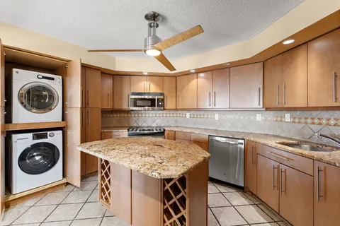 a kitchen with a sink a stove top oven and cabinets
