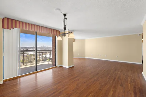a view of a room with wooden floor fan and windows