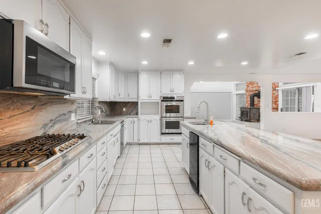 an empty room with windows and ceiling fan