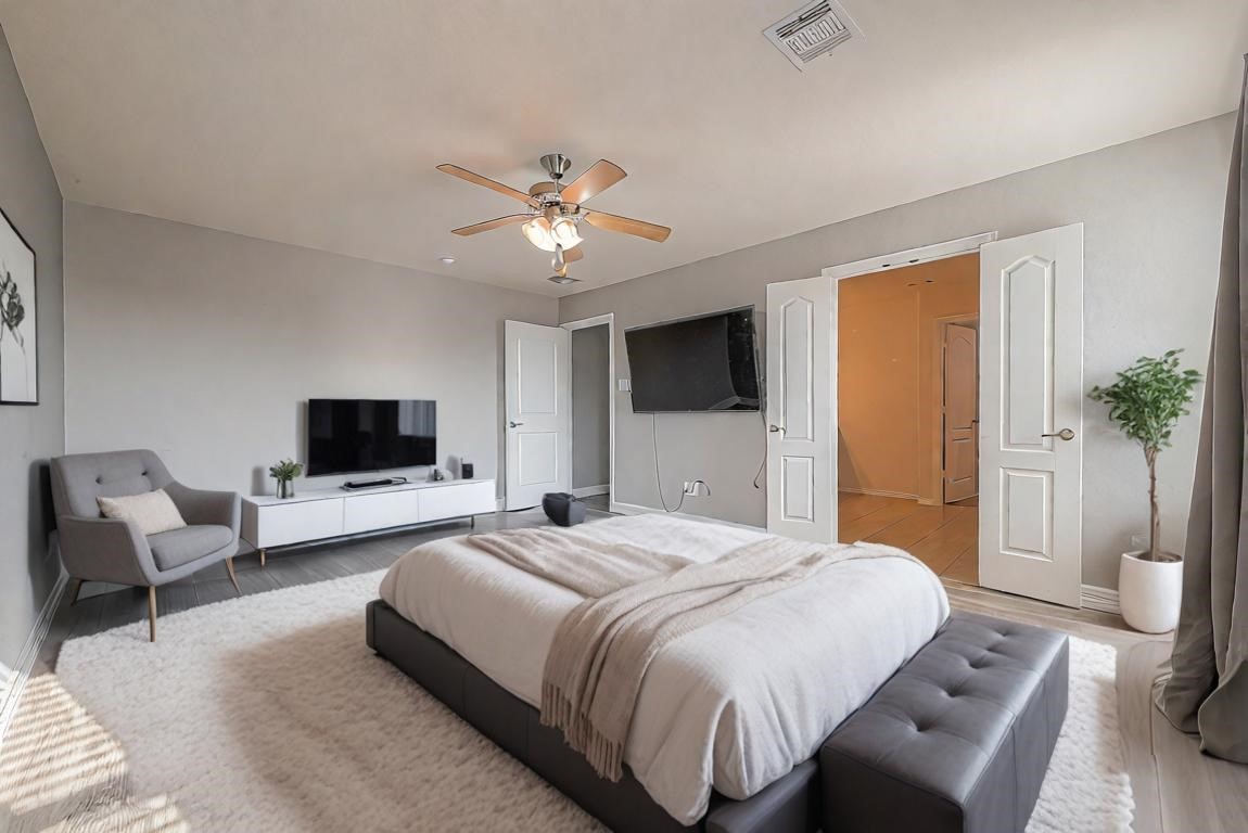 223 Sintra Lk Way Rosenberg, TX 77469 - Photo 18 of 43 a bedroom with a bed a mirror on dresser and a flat screen tv