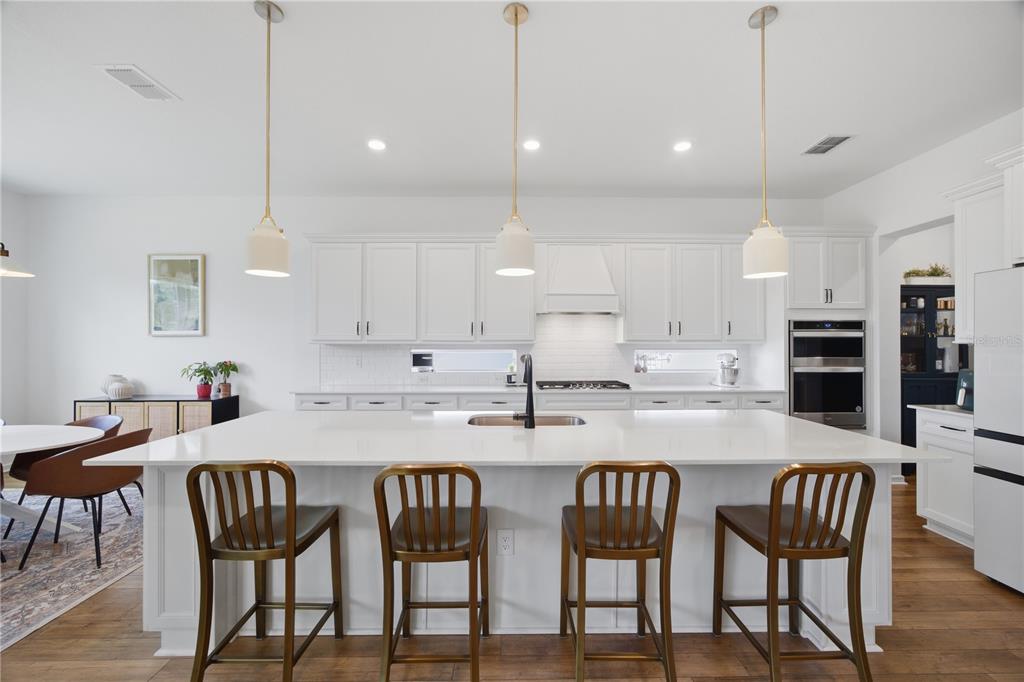 13816 Sharp Hawk Drive Riverview, FL 33569 - Photo 19 of 76 a kitchen with stainless steel appliances kitchen island granite countertop a dining table chairs and a refrigerator