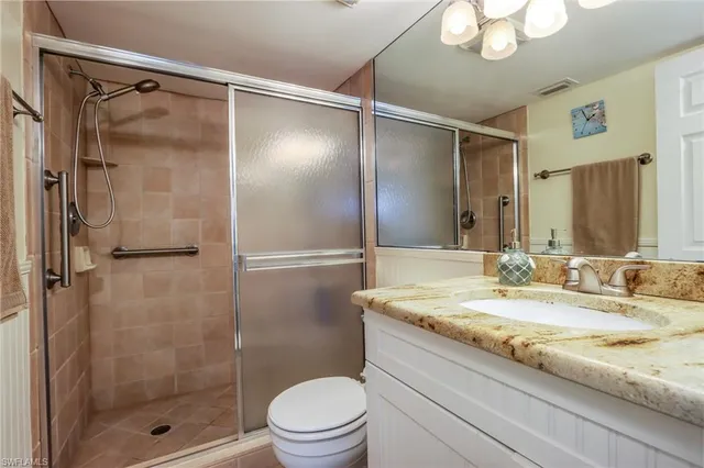 a bathroom with a granite countertop sink toilet and shower