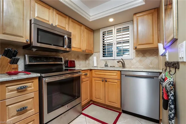 a kitchen with stainless steel appliances granite countertop a stove microwave and sink