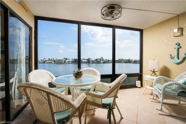 a dining room with furniture and a floor to ceiling window