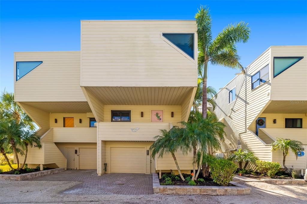 546A Beach Road, Unit A544 Sarasota, FL 34242 - Photo 2 of 59 a view of a house with a yard and palm trees
