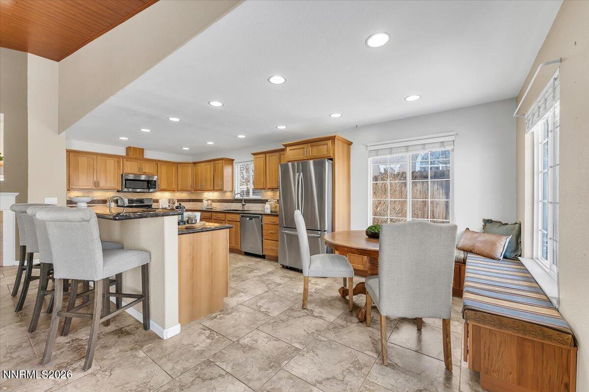 65 Rook Court Sparks, NV 89441 - Photo 16 of 41 a dining hall with stainless steel appliances kitchen island granite countertop a dining table chairs and a refrigerator