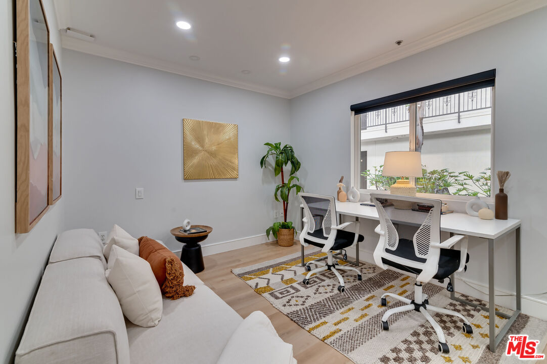 1878 Greenfield Avenue, Unit 104 Los Angeles, CA 90025 - Photo 14 of 35 a living room with furniture a wooden floor and a large window