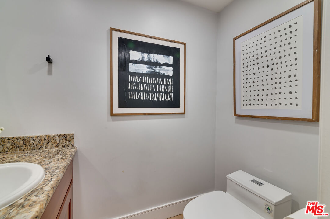 1878 Greenfield Avenue, Unit 104 Los Angeles, CA 90025 - Photo 22 of 35 a white toilet sitting next to a bathroom sink