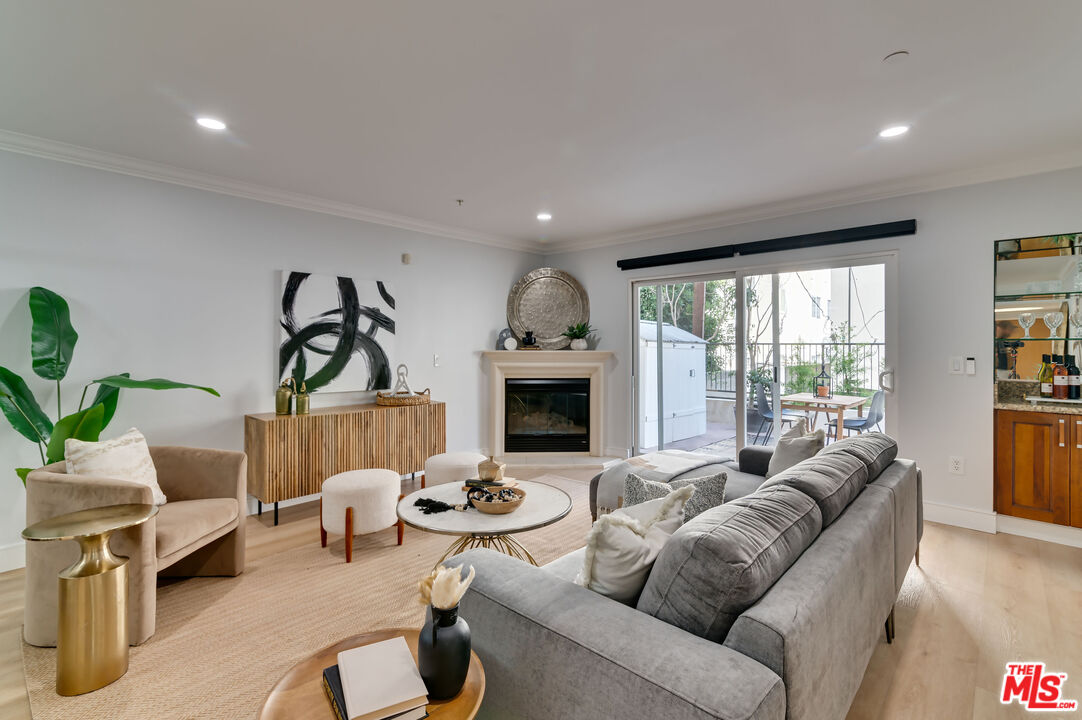 1878 Greenfield Avenue, Unit 104 Los Angeles, CA 90025 - Photo 7 of 35 a living room with furniture large window and a fireplace