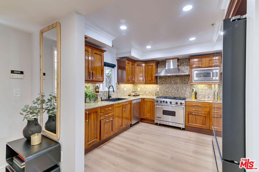 1878 Greenfield Avenue, Unit 104 Los Angeles, CA 90025 - Photo 8 of 35 a large kitchen with stainless steel appliances granite countertop a stove a sink and a refrigerator