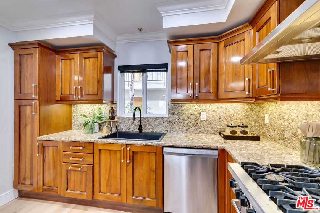 1878 Greenfield Avenue, Unit 104 Los Angeles, CA 90025 - Photo 9 of 35 a kitchen with granite countertop a sink stainless steel appliances and cabinets