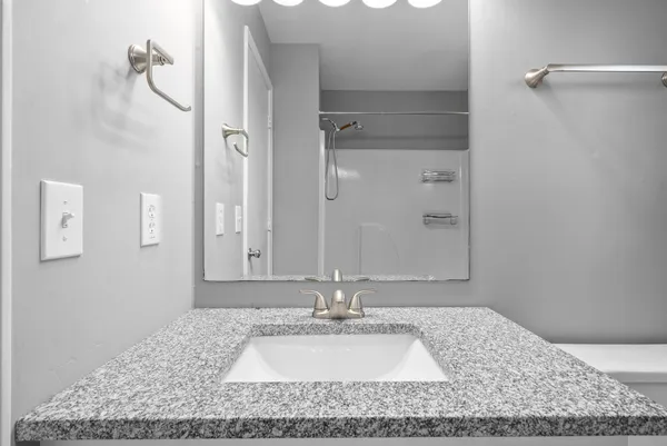 a bathroom with a granite countertop sink and a mirror
