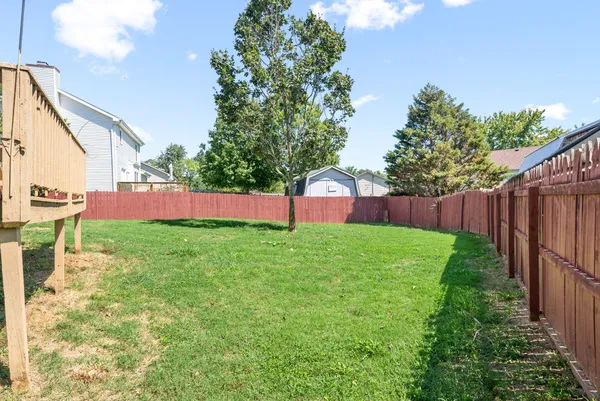 a view of backyard with wooden fence